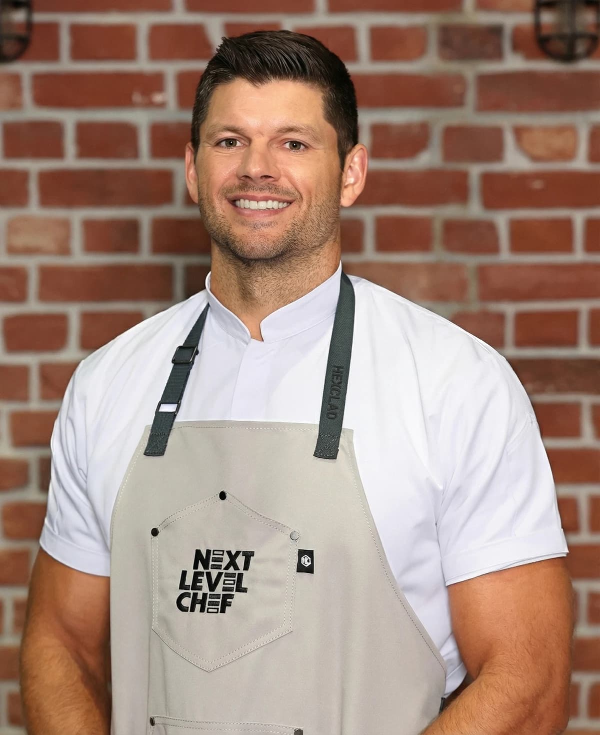 Jared Veldheer wearing a chef's coat and Next Level Chef apron.